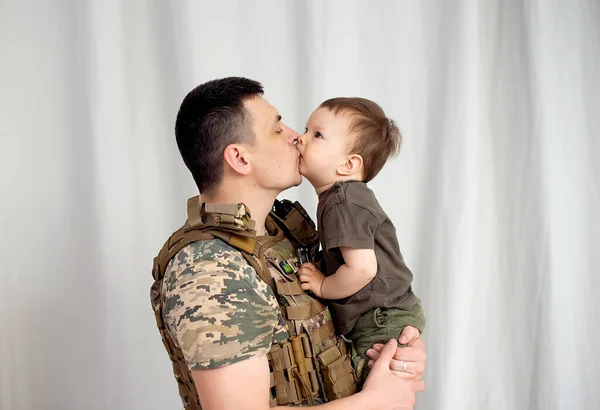 son says goodbye to her military . Son hugs a dad Ukrainian soldier. Ukrainian defender says goodbye to his family. Mobilization of Ukrainian men