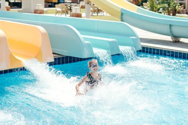 Mutlu küçük kız yaz tatilinde eğleniyor. Su parkında yaz tatilinde dinlenen mutlu çocuk.