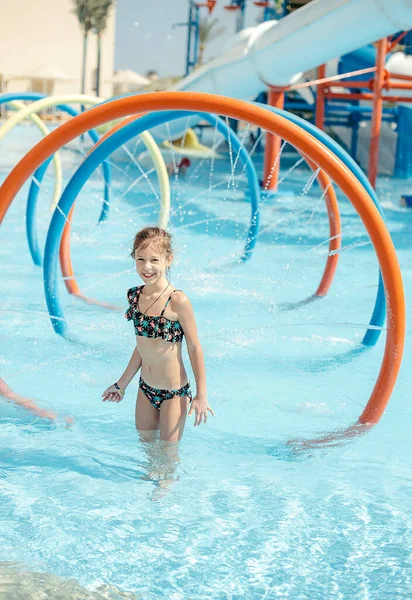 Mutlu küçük kız yaz tatilinde eğleniyor. Su parkında yaz tatilinde dinlenen mutlu çocuk.