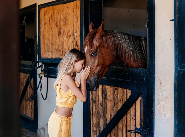 馬小屋で馬を持つ 代の少女の肖像画 — ストック写真