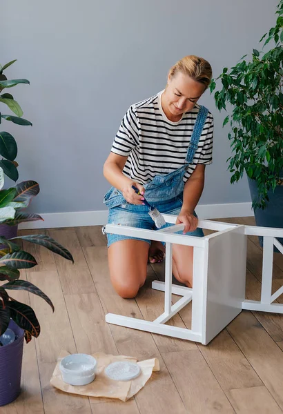 stock image Woman at home painting a chair or painting as upcycling
