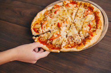 İnsanlar Pizza Margherita 'dan bir dilim alıyor. Pizza Margarita ve Eller arka planda kapanıyor