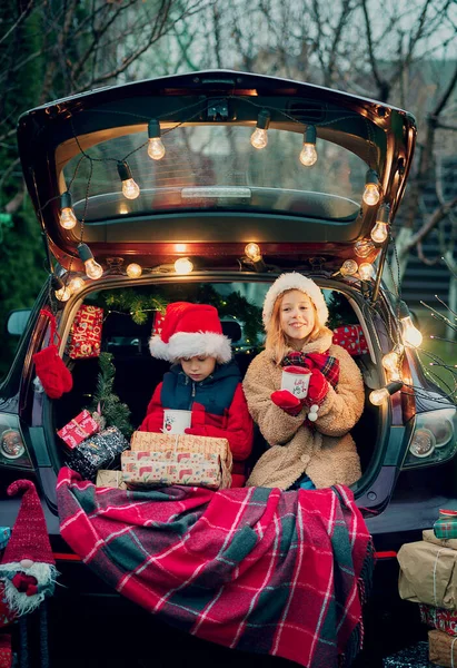 Mutlu noeller. Noel hediyeli çocuklar dışarıda.