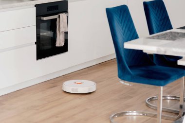 Beyaz robot süpürge yerleri yıkıyor..