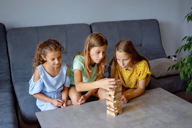 Arkadaşlar evde masa oyunu oynuyorlar. Çocuklar stratejik oyunlar oynar. Yaz tatili için eğlenceli bir ev aktivitesi. Arkadaşlar oyun gecesinin tadını çıkarın