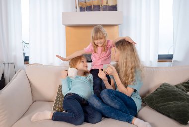 Kızım çay içiyor ve kış akşamı şöminenin yanında gülüyor.