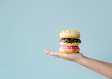 Elle tutulan üç donut, ana yemek malzemeli fırınlanmış yiyecekler.