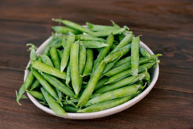 Ahşap arka planda taze bezelyeler. tahta masa arkaplanı