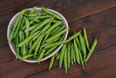 Ahşap arka planda taze bezelyeler. tahta masa arkaplanı