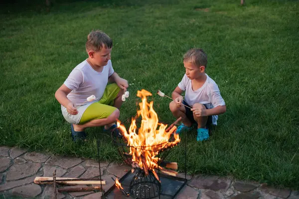 İki çocuk lokum kızartıyor.