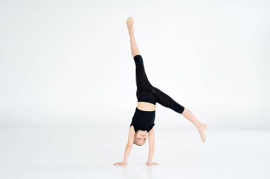 Küçük şirin kız içeride amuda kalkıyor. Jimnastik