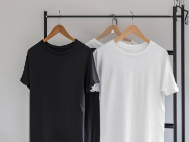 Gerçekçi t-shirt modeli (124); Askıda boş siyah beyaz tişört, tasarım modeli. Sade pamuk tişörtü şablonu oluşturur. Giyim mağazası logosu sahte markalaşma görüntüsü