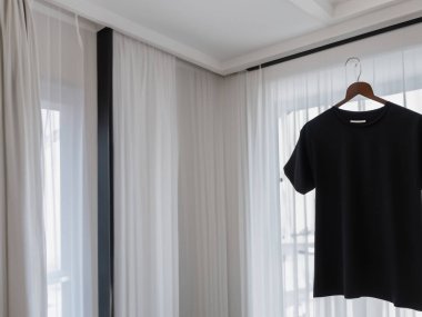 Gerçekçi t-shirt modeli (124); Askıda boş siyah beyaz tişört, tasarım modeli. Sade pamuk tişörtü şablonu oluşturur. Giyim mağazası logosu sahte markalaşma görüntüsü