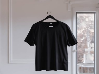 Gerçekçi t-shirt modeli (124); Askıda boş siyah beyaz tişört, tasarım modeli. Sade pamuk tişörtü şablonu oluşturur. Giyim mağazası logosu sahte markalaşma görüntüsü