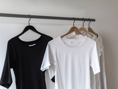 Gerçekçi t-shirt modeli (124); Askıda boş siyah beyaz tişört, tasarım modeli. Sade pamuk tişörtü şablonu oluşturur. Giyim mağazası logosu sahte markalaşma görüntüsü