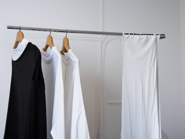 Gerçekçi t-shirt modeli (124); Askıda boş siyah beyaz tişört, tasarım modeli. Sade pamuk tişörtü şablonu oluşturur. Giyim mağazası logosu sahte markalaşma görüntüsü