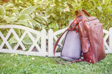 Sırt çantası, uyku tulumu ve bahçede güneş gözlüğü. Tatil ve seyahat konsepti. Eski tarz. Boşluğu kopyala.