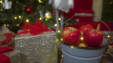 Noel Ağacı 'nda kırmızı ve parlak süslemeleri olan bir Noel süslemesi. Noel süslemeleri ve hediyeli kompozisyon. Kamera aşağıdan yukarıya doğru sorunsuzca hareket eder.