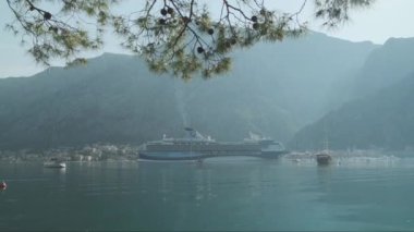 Kotor Körfezi 'nde dağların arkasında bir gemi gezisi. Yüksek kalite 4k görüntü