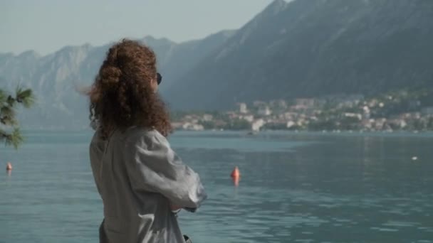 Woman Curly Hair Gazes Thoughtfully Peaceful Sea Bay Mountains Immersed — Stockvideo
