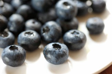 Beyaz tabakta taze yaban mersini yakın plan.