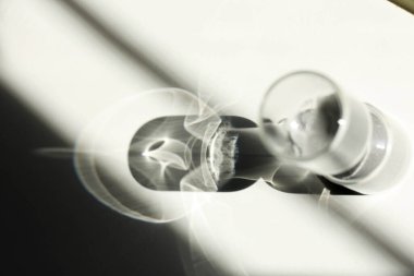 Masanın üzerindeki kum saati ışık, gölge ve cam yansımaları vuruyor.