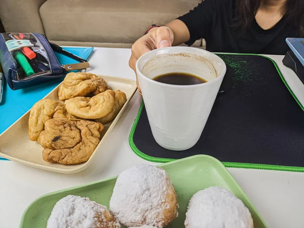 一位年轻妇女在工作时间休息时喝了一杯咖啡 并配上小吃 — 图库照片