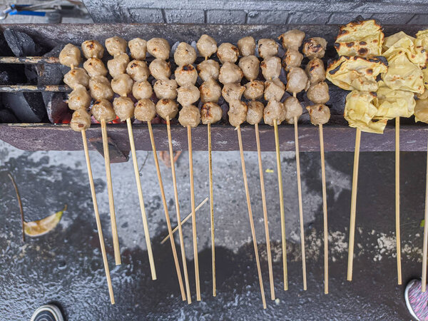 жареные фрикадельки. традиционная уличная местная еда в Индонезии, где производственный процесс готовится на горячем угле