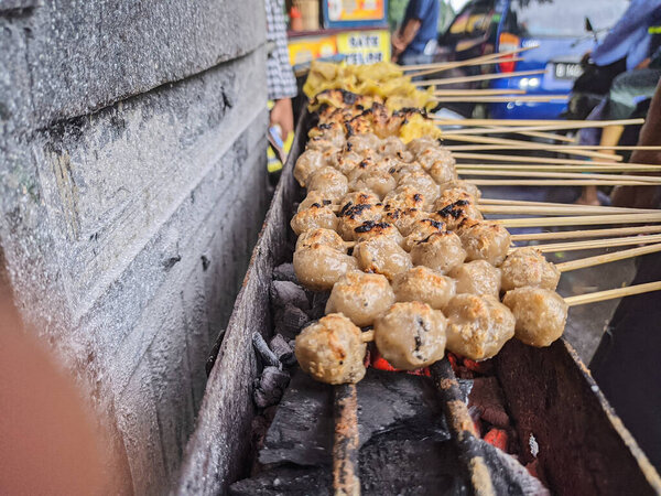 жареные фрикадельки. традиционная уличная местная еда в Индонезии, где производственный процесс готовится на горячем угле