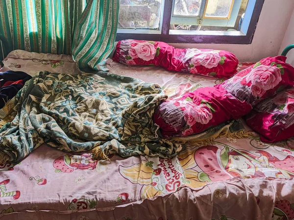 The bedroom is a mess. A child\'s room with a messy bed and pillows, bolsters and quilts that have not been tidied up. real life.