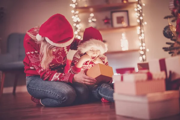 stock image Mother and son indoors looking inside of gift box in Christmas eve. Concept of Christmastime and New Year.