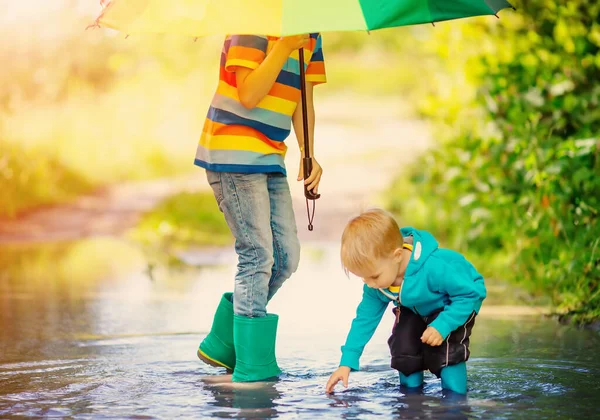 Two Brothers Standing Rainbow Umbrella Puddle Concept Family Relation Love — Zdjęcie stockowe