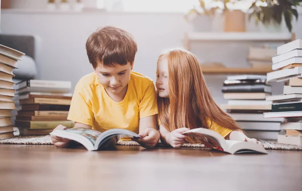 Zwei Niedliche Kinder Liegen Drinnen Mit Büchern Auf Dem Kopf — Stockfoto