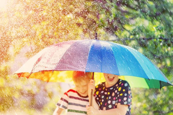 Junge Und Mädchen Stehen Bei Regnerischem Wetter Unter Bunten Regenschirmen — Stockfoto