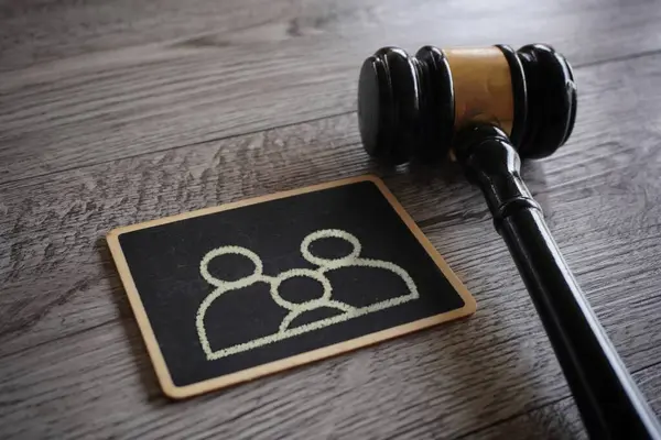 Closeup image judge gavel and chalkboard with family icon. Guardianship, family law concept.