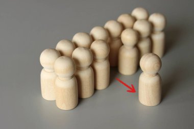 Tahta bir bebeğin seçici odak görüntüsü gruptan ayrılır. Katılmayı reddetmek, protesto için geri çekilmek. Çıkış projesi, iş kavramından azledilme