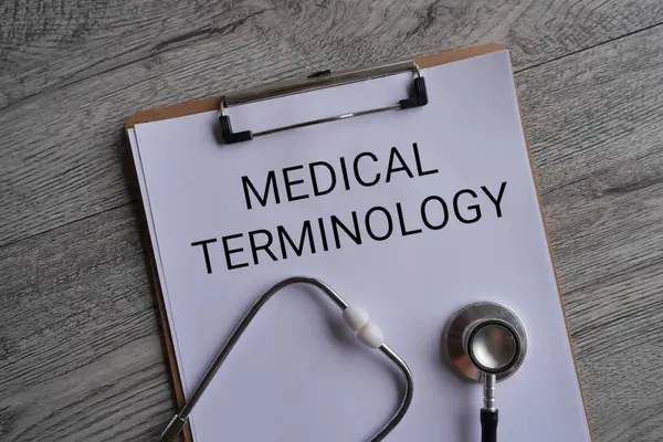 Stetoskop ve kağıt panosunun üst görünümü ve metin MEDICAL TERMINOLOGY. Tıbbi ve sağlık hizmeti kavramı.