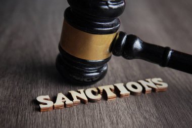 Yargıç Tokmak 'ın resmini kapat ve ahşap masaya SANCTIONS' u yaz.