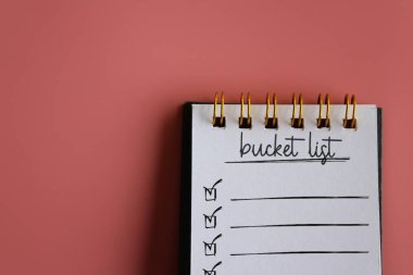 Not defterinin üst görünümü metin BUCKET LIST üzerinde kopyalama alanı ile pembe arkaplan. 