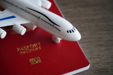 Oyuncak uçak ve pasaportun yakın plan görüntüsü. Seyahat ve tatil kavramı