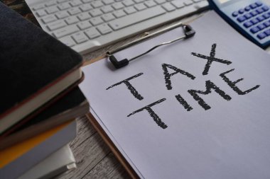 Metin Vergi Zamanı, hesap makinesi, kitaplar ve klavyeli kağıt panonun yakın plan resmi. Finans kavramı
