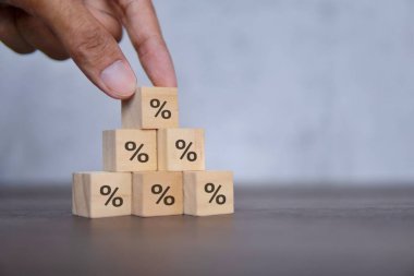 Yüzdelik simgeyle ahşap blokları elle düzenleme. Borç yapılandırma kavramı.