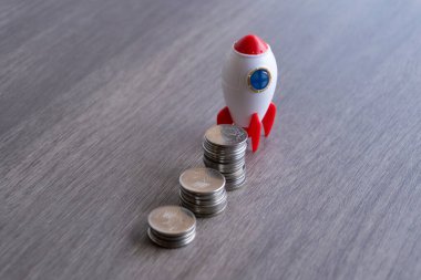 Roket uzay gemisi ve madeni paraların yakın görüntüsü. İş kurma, başlatma ve geliştirme kavramı.