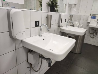 Modern banyo lavabosu ve umumi tuvalet ve tuvalette dokunulamaz musluk..