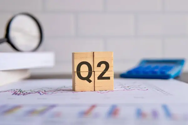 Ofis masasında alfabe Q2 olan tahta küplerin resmini kapat. İkinci çeyrek kavramı.