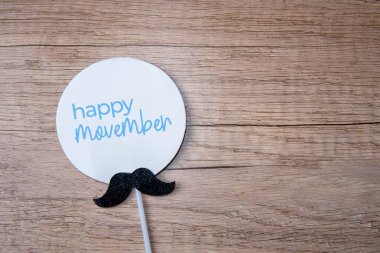 Bir steteskop ve tahta bir masaya yerleştirilmiş bıyık kesiği. Erkek sağlığı, prostat kanseri konsepti için Movember farkındalığı.