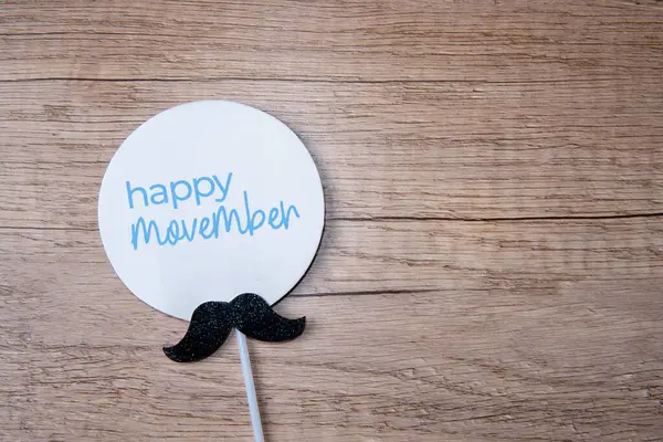 Bir steteskop ve tahta bir masaya yerleştirilmiş bıyık kesiği. Erkek sağlığı, prostat kanseri konsepti için Movember farkındalığı.