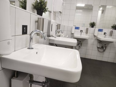 Modern banyo lavabosu ve umumi tuvalet ve tuvalette dokunulamaz musluk..