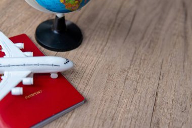 Pasaportun üstünde küçük bir model uçak ve küçük bir kürenin yanında. Uzayı metin için kopyala. Seyahat, küresel bağlantılar ve uluslararası seyahat kavramı.