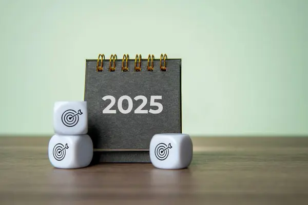 2025 masa takvimi ve hedef tahtası simgesi olan beyaz zarlar. Yeni Yıl Kararları, Hedef ve Hedefler kavramı.